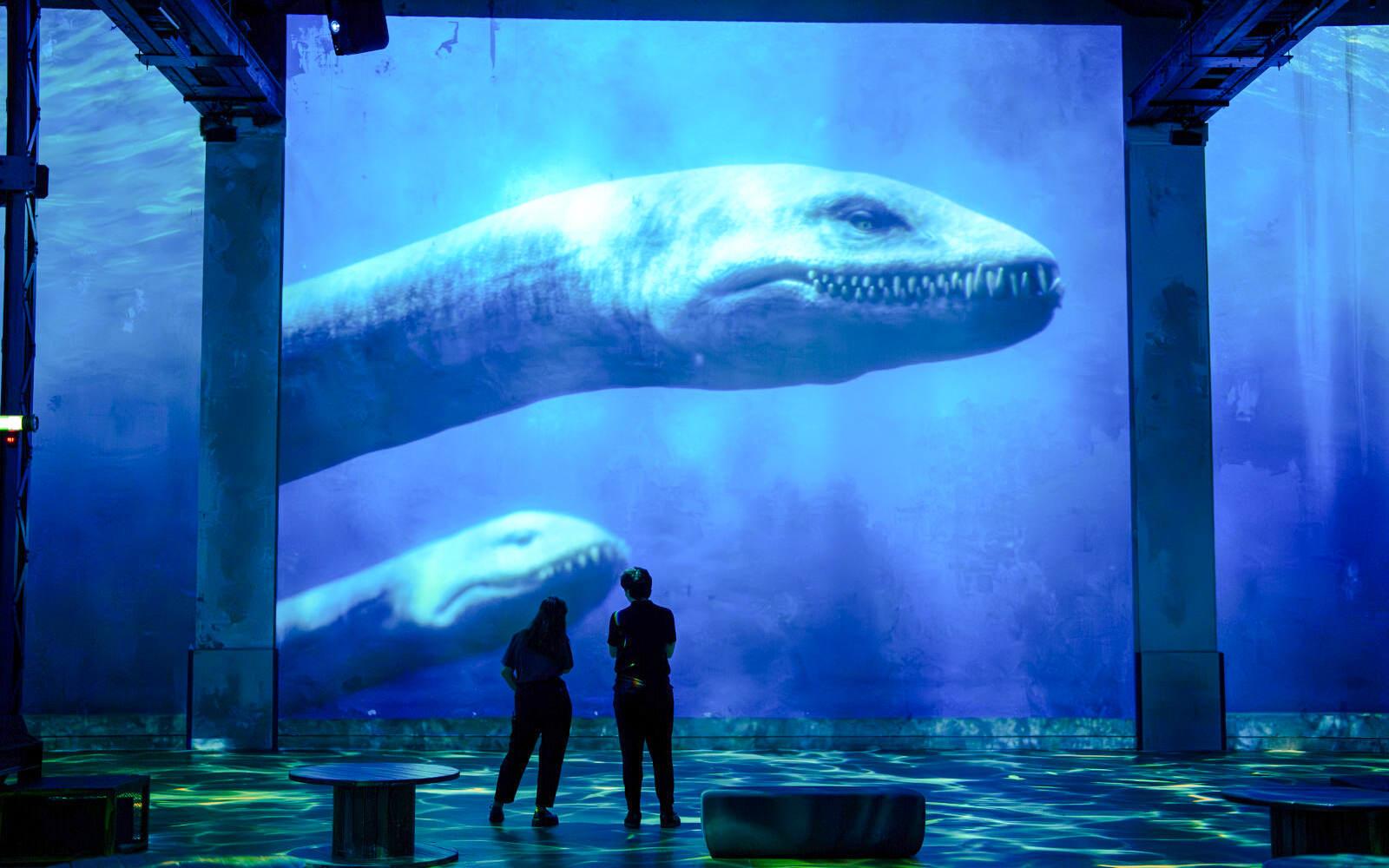 Visitors viewing dinosaur projection at Prehistoric Planet exhibition, Atelier des Lumières.
