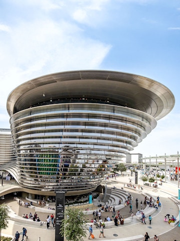 Aerial view of Expo City Dubai entrance with futuristic architecture and surrounding landscape.
