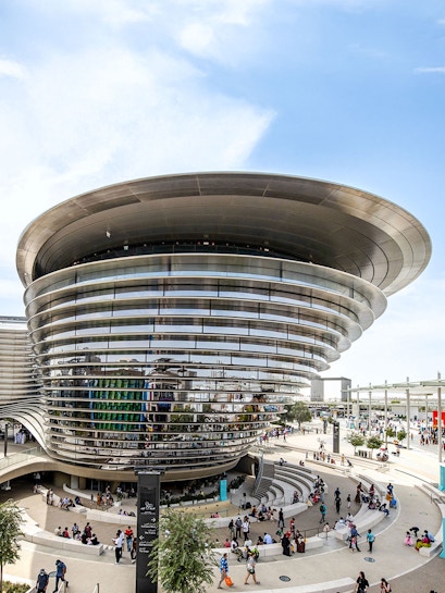 Aerial view of Expo City Dubai entrance with futuristic architecture and surrounding landscape.