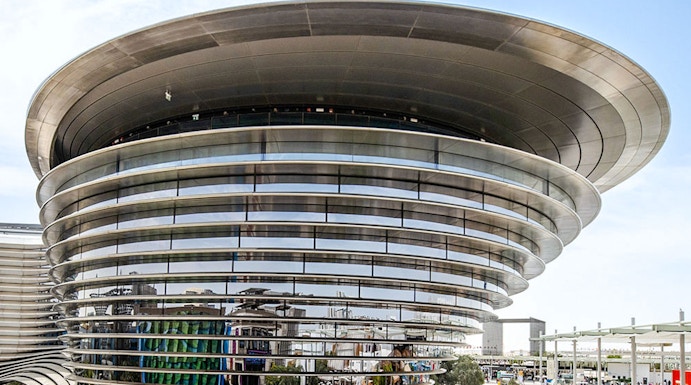 Aerial view of Expo City Dubai entrance with futuristic architecture and surrounding landscape.