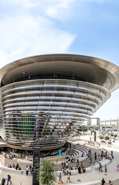 Aerial view of Expo City Dubai entrance with futuristic architecture and surrounding landscape.