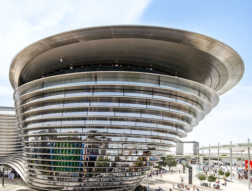 Aerial view of Expo City Dubai entrance with futuristic architecture and surrounding landscape.