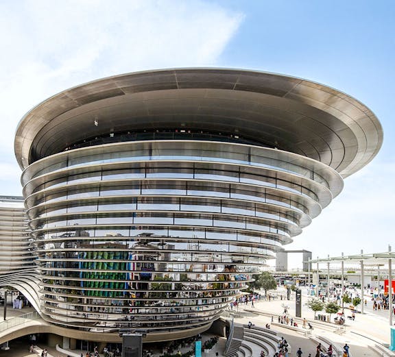 Aerial view of Expo City Dubai entrance with futuristic architecture and surrounding landscape.