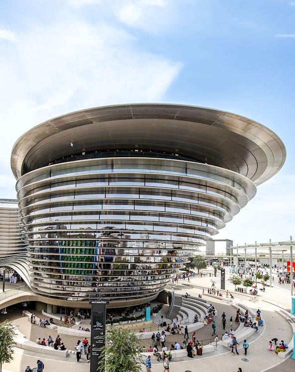 Aerial view of Expo City Dubai entrance with futuristic architecture and surrounding landscape.