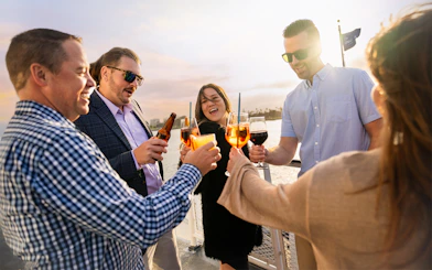 Guests toasting drinks on the deck during San Diego Premier Dinner Cruise.