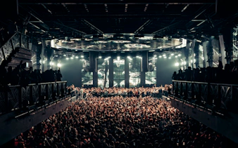 Black Coffee performing at UNVRS Ibiza with a large crowd and vibrant stage lights.