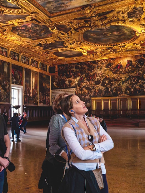 Visitors admiring ornate ceiling and artwork during Doge Palace guided tour in Venice.