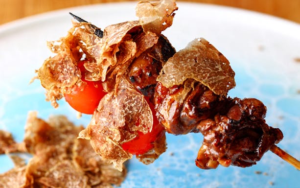 Yakitori skewer with truffle shavings and cherry tomatoes at Yakitori Tsukiya.