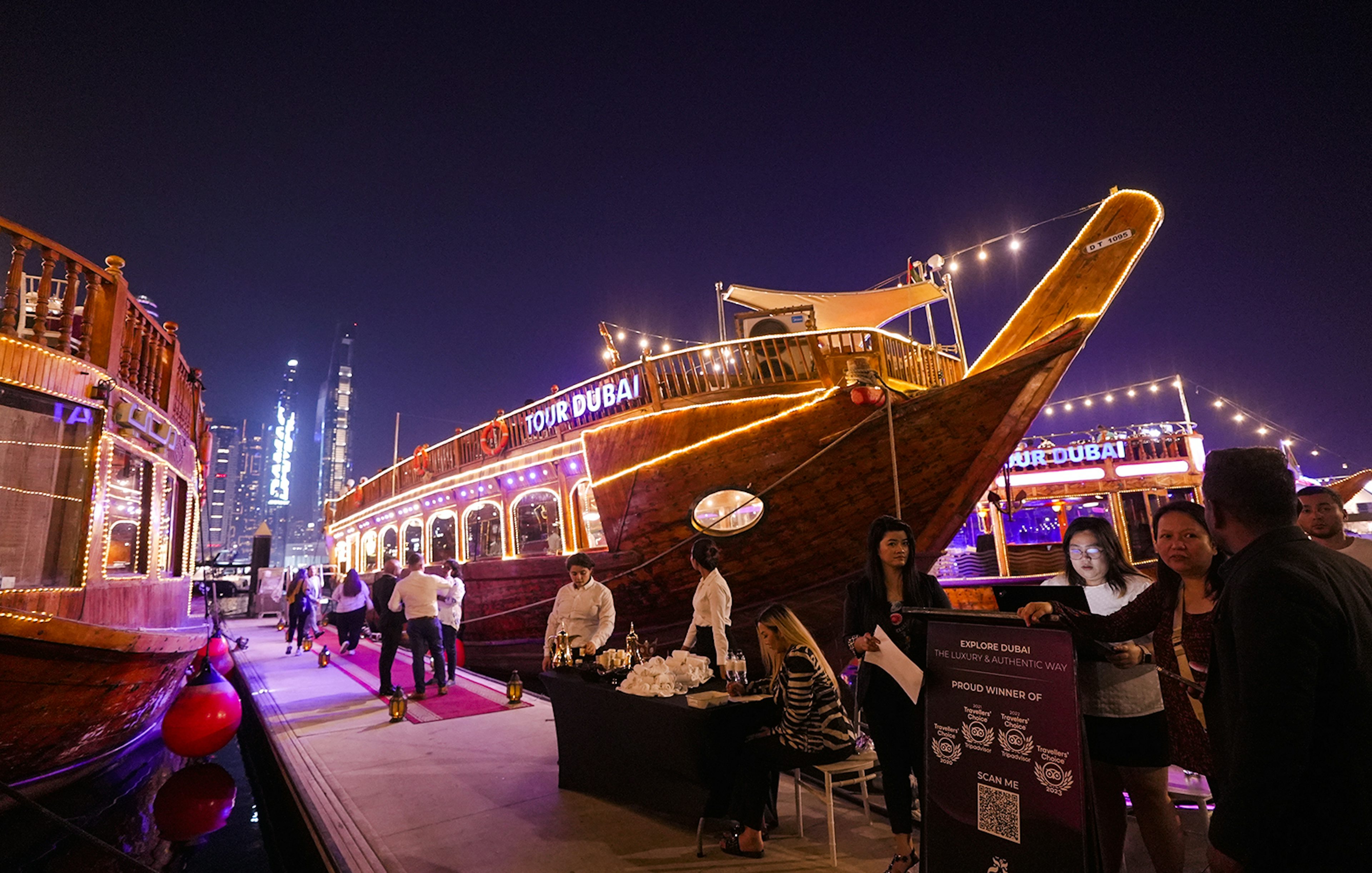 Dubai Marina dhow cruise with guests boarding for a 5-star Indian dinner experience.