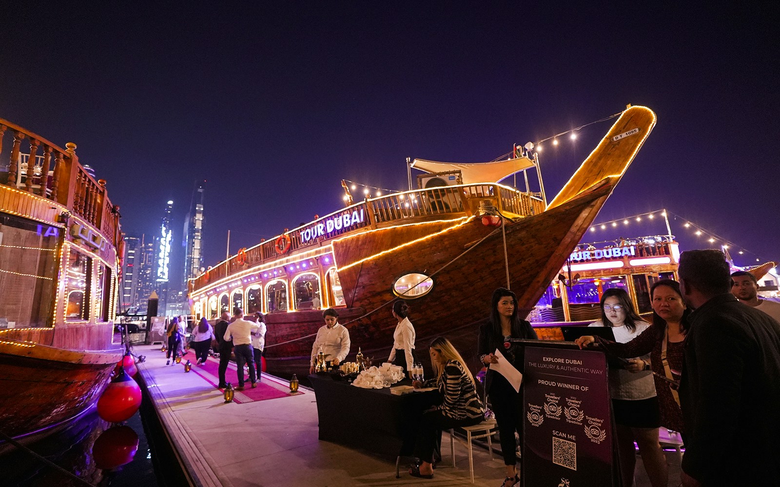 Dubai Marina dhow cruise with guests boarding for a 5-star Indian dinner experience.
