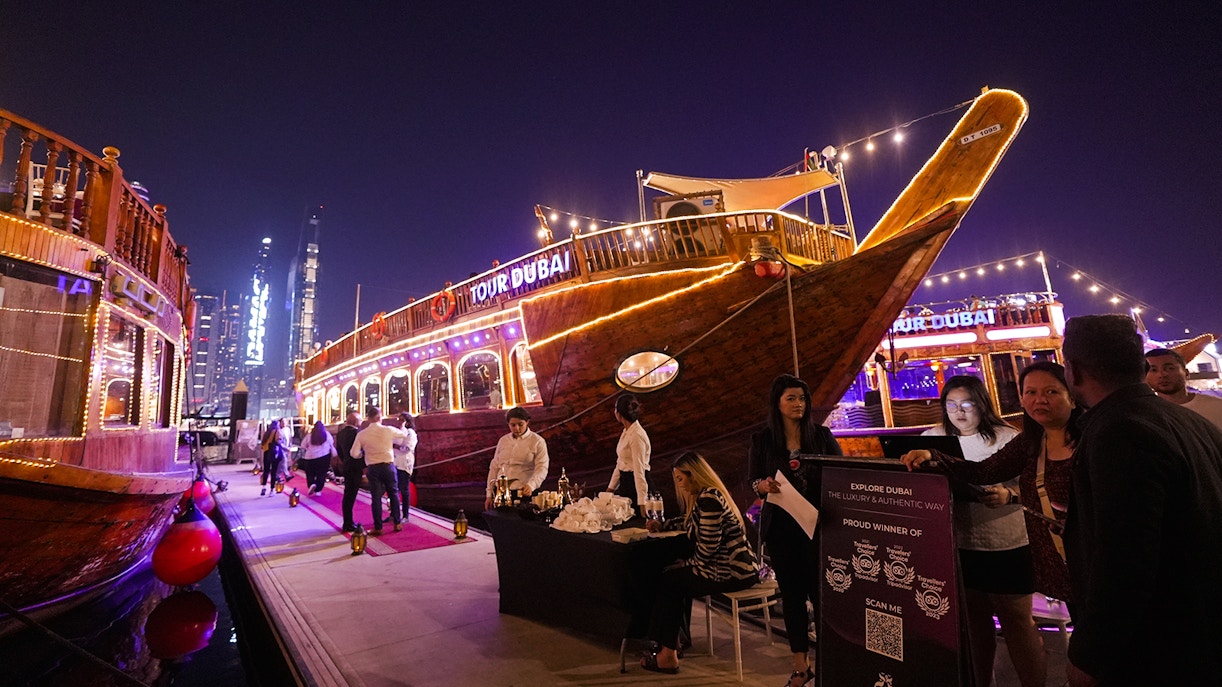 Dubai Marina dhow cruise with guests boarding for a 5-star Indian dinner experience.