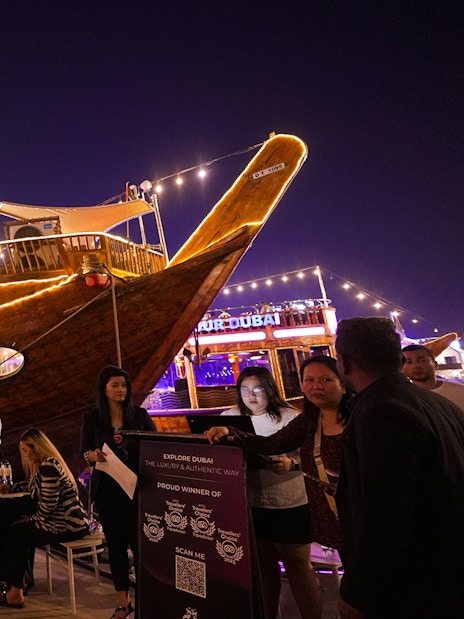 Dubai Marina dhow cruise with guests boarding for a 5-star Indian dinner experience.