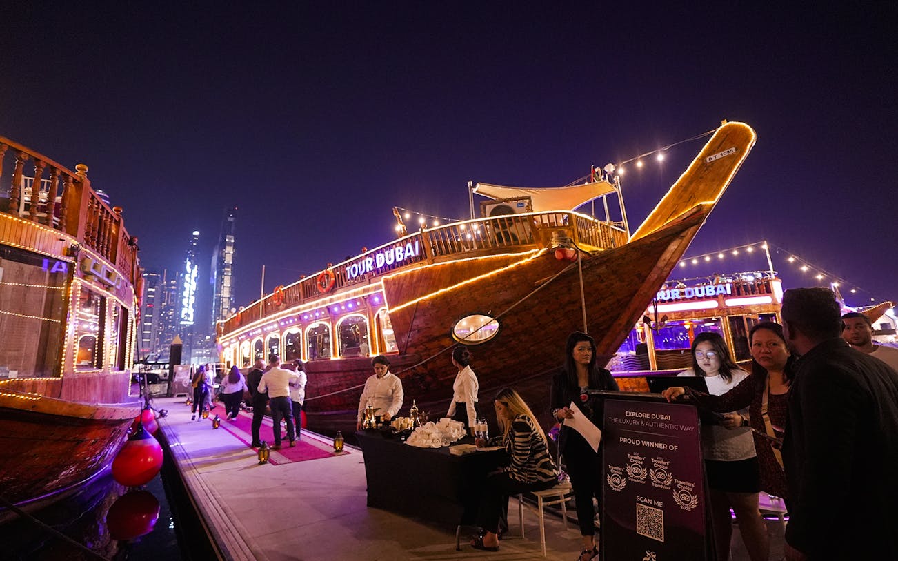 Dubai Marina dhow cruise with guests boarding for a 5-star Indian dinner experience.