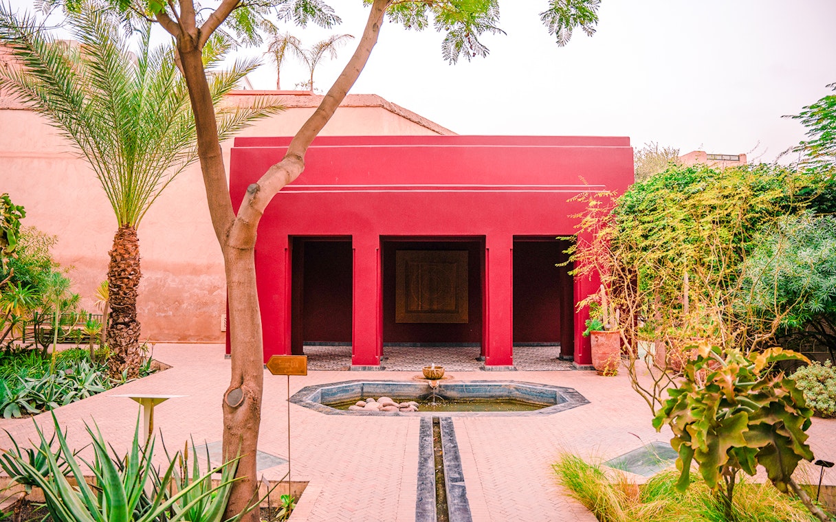 Jardin Secret courtyard with red building and fountain in Marrakech, Morocco.