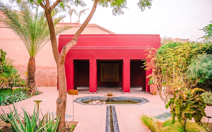 Jardin Secret courtyard with red building and fountain in Marrakech, Morocco.