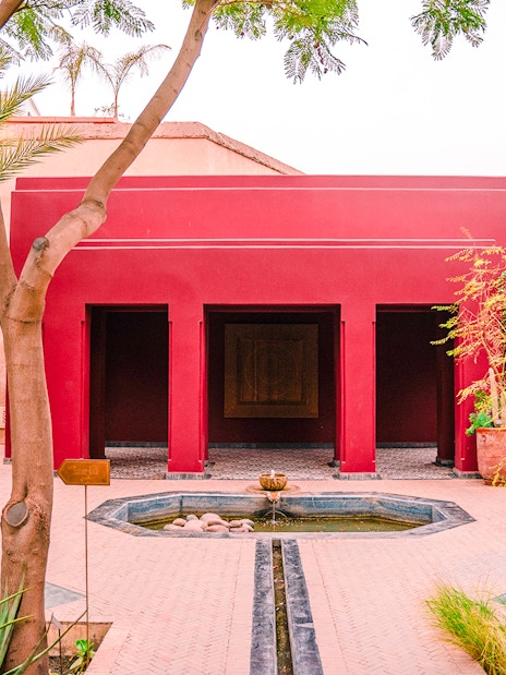 Jardin Secret courtyard with red building and fountain in Marrakech, Morocco.