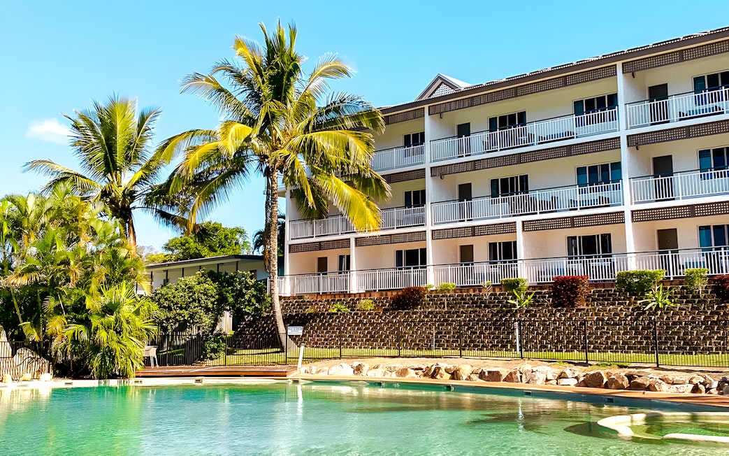 K'gari Beach Resort pool area with palm trees, Fraser Island.