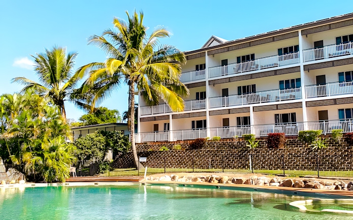 K'gari Beach Resort pool area with palm trees, Fraser Island.