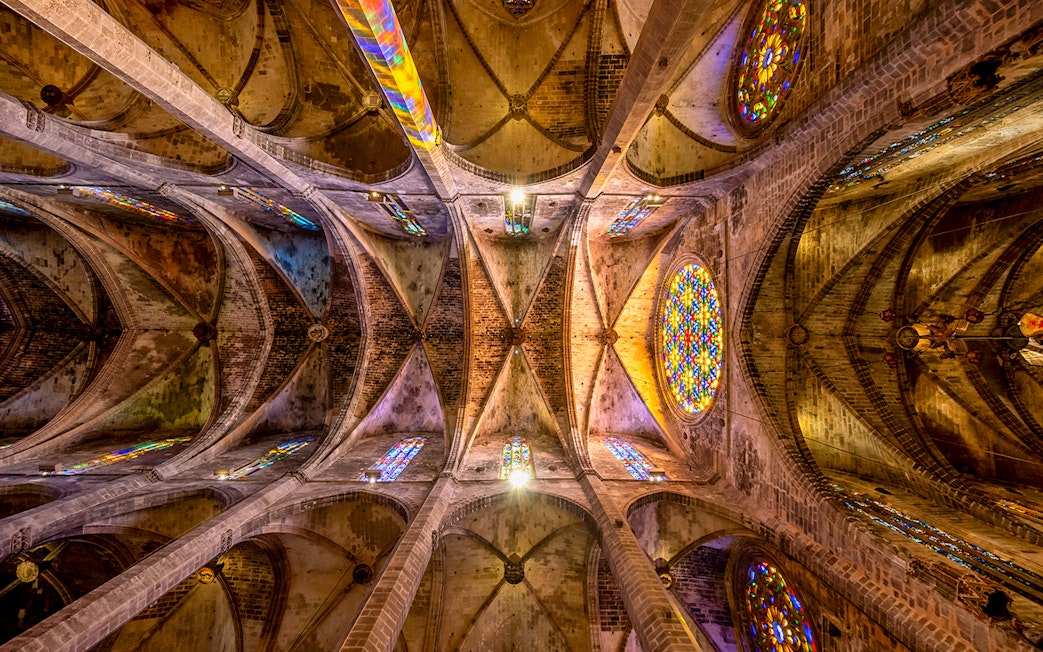 Ceiling view of Santa Maria de Majorica's gothic cathedral in Palma with stained glass windows.
