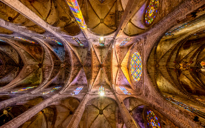 Ceiling view of Santa Maria de Majorica's gothic cathedral in Palma with stained glass windows.