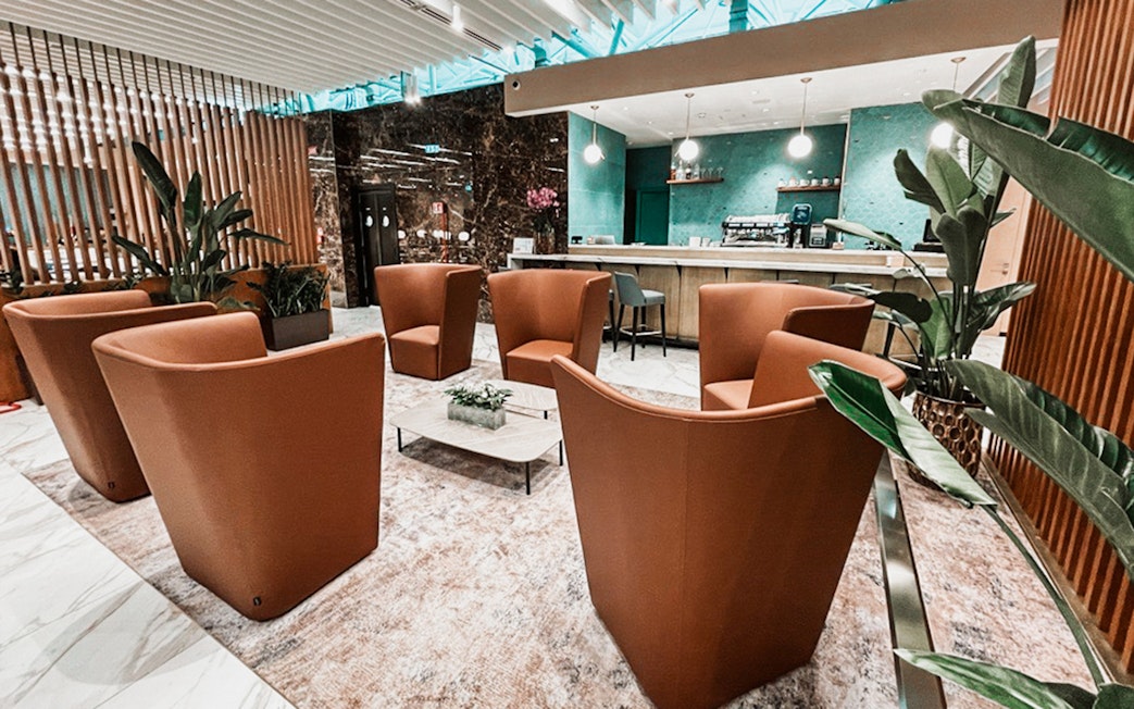 Premium lounge seating area at Rome Fiumicino Airport with modern decor and bar.