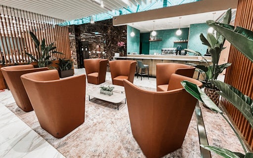 Premium lounge seating area at Rome Fiumicino Airport with modern decor and bar.
