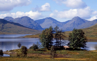 Loch Lomond with surrounding hills and trees in Scotland.