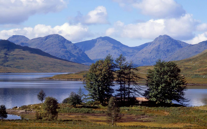Loch Lomond with surrounding hills and trees in Scotland.