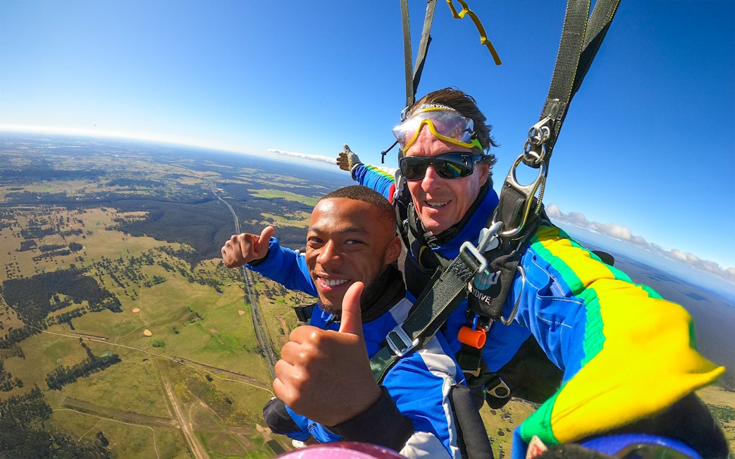 Tandem skydive over Sydney with scenic landscape view, part of city transfer tour.