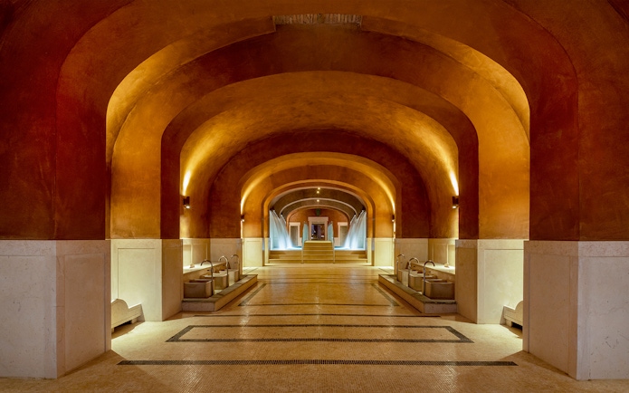 Spa interior with arched ceilings and fountains at QC Terme Roma, Italy.