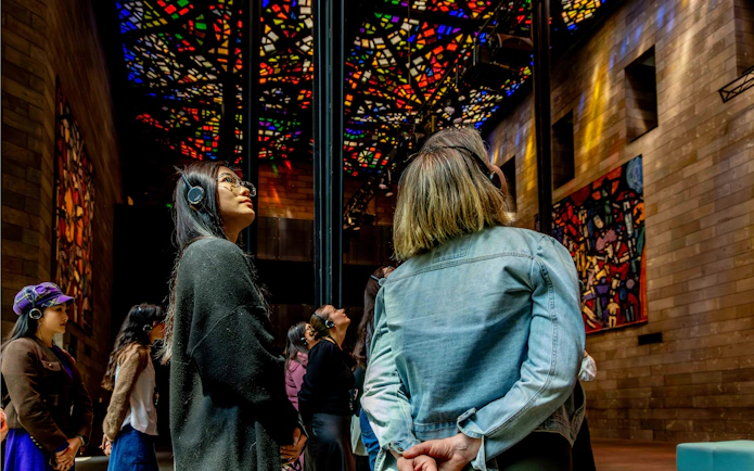 Visitors observing stained glass ceiling at National Gallery of Victoria during Best of NGV Experiences Tour.