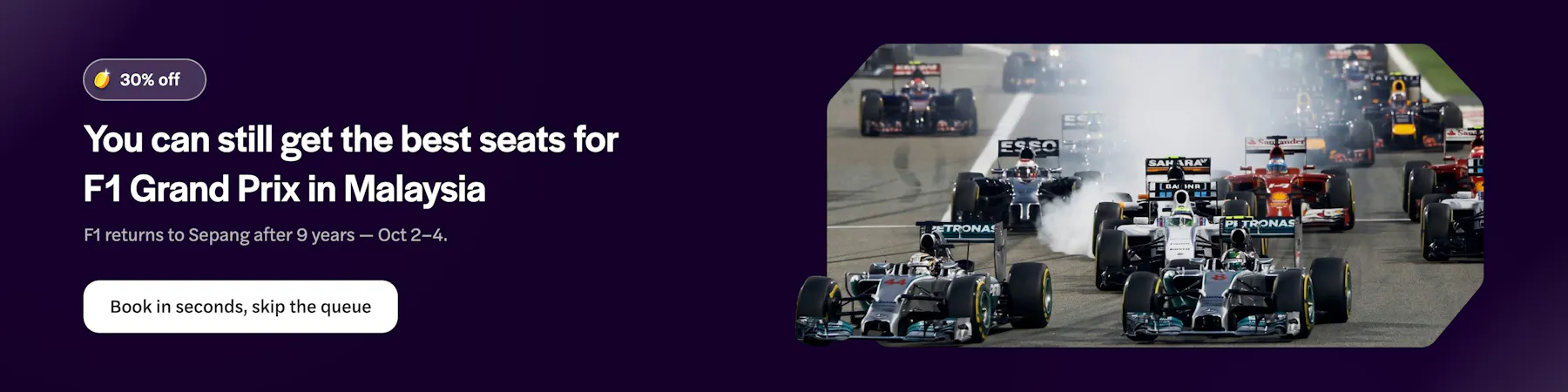Formula 1 cars racing on track at Malaysia Grand Prix.