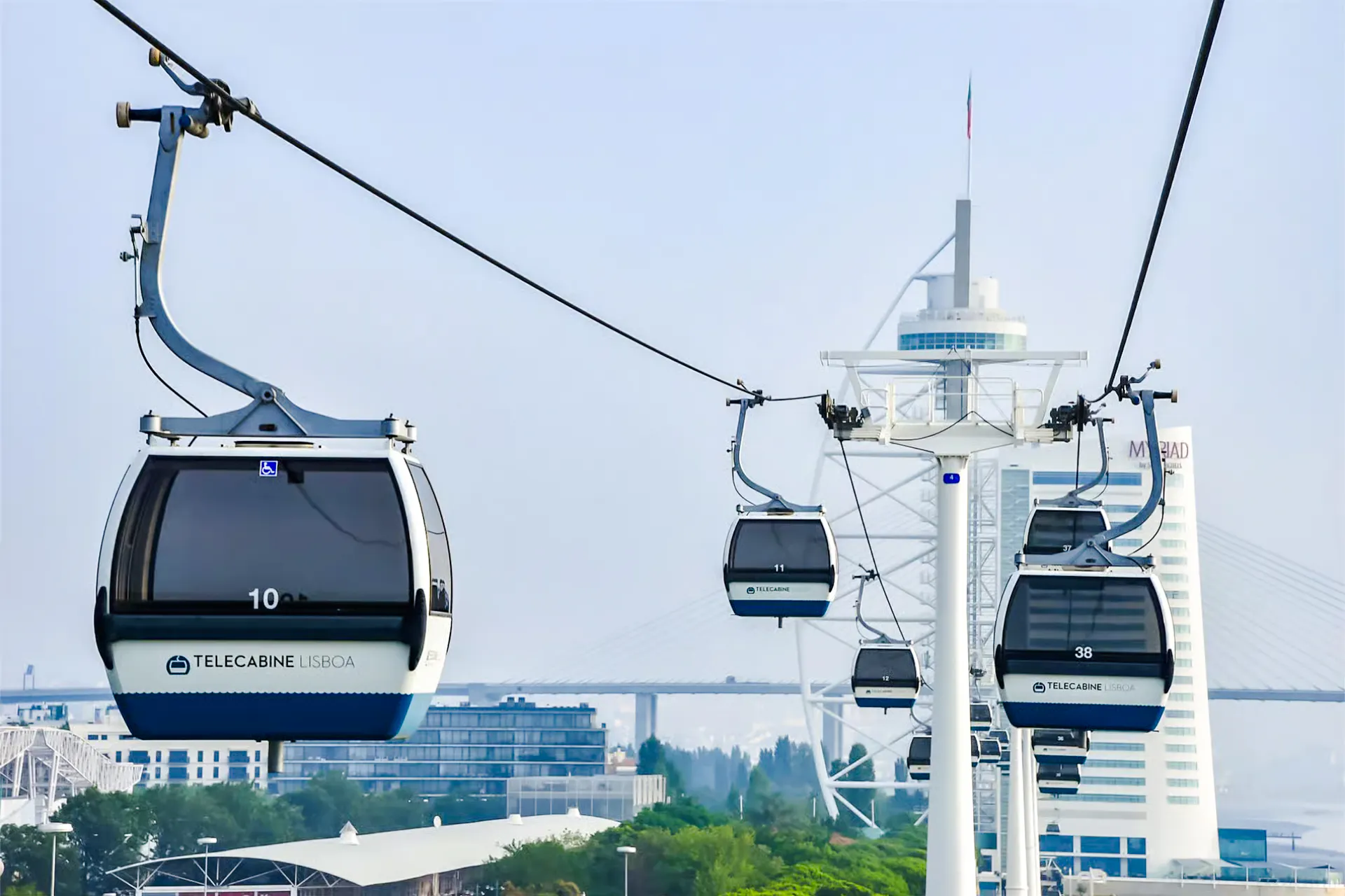 Lisbon cable cars over the cityscape with modern buildings in the background.