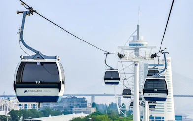 Lisbon cable cars over the cityscape with modern buildings in the background.