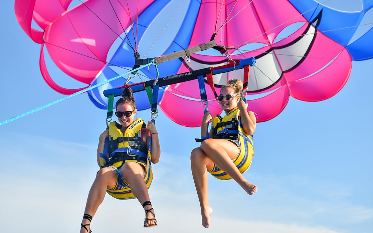 Parasailing adventure with colorful parachute over the ocean.
