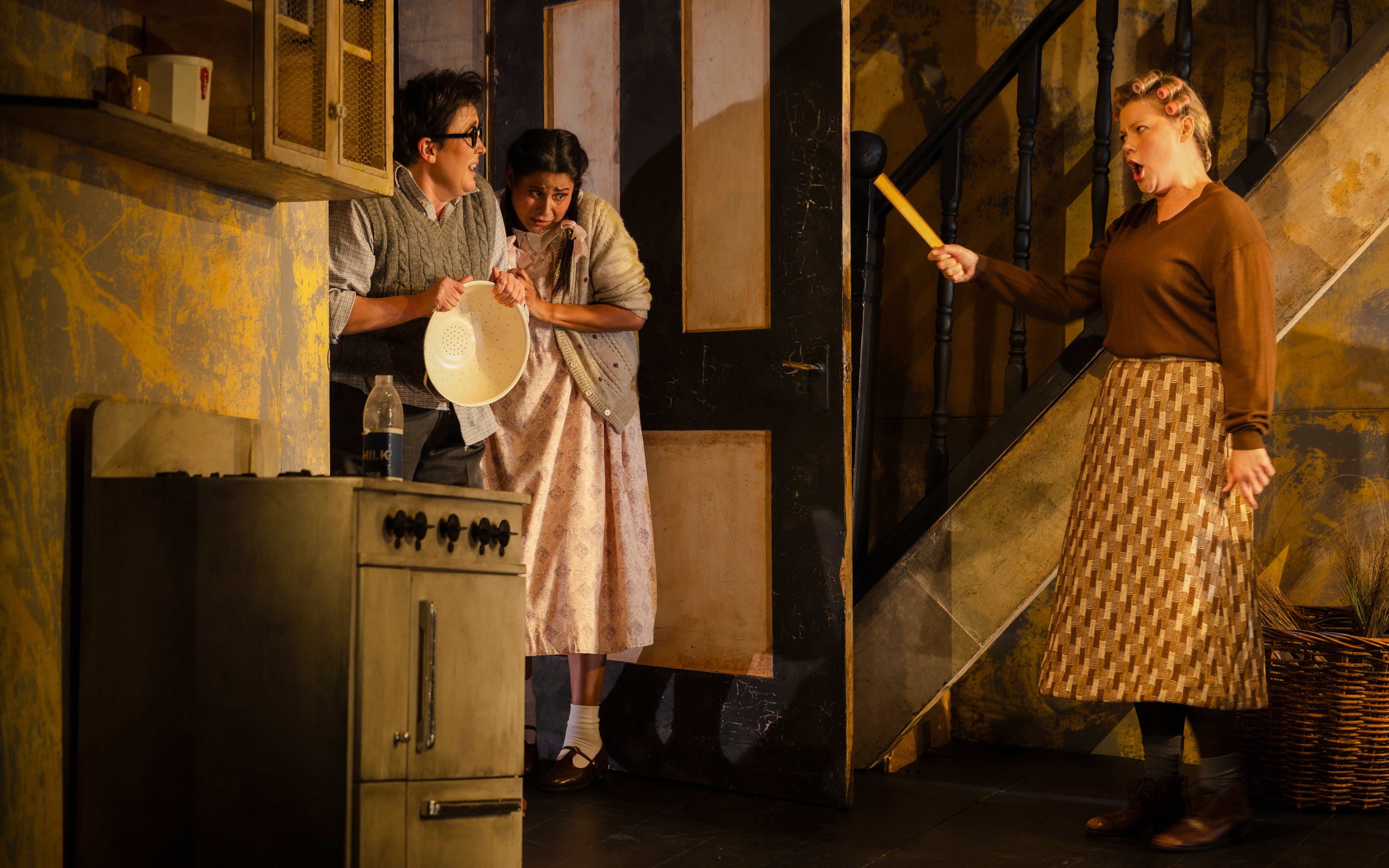 Hansel and Gretel stage performance with actors in a kitchen scene.
