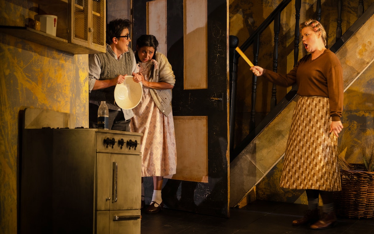 Hansel and Gretel stage performance with actors in a kitchen scene.
