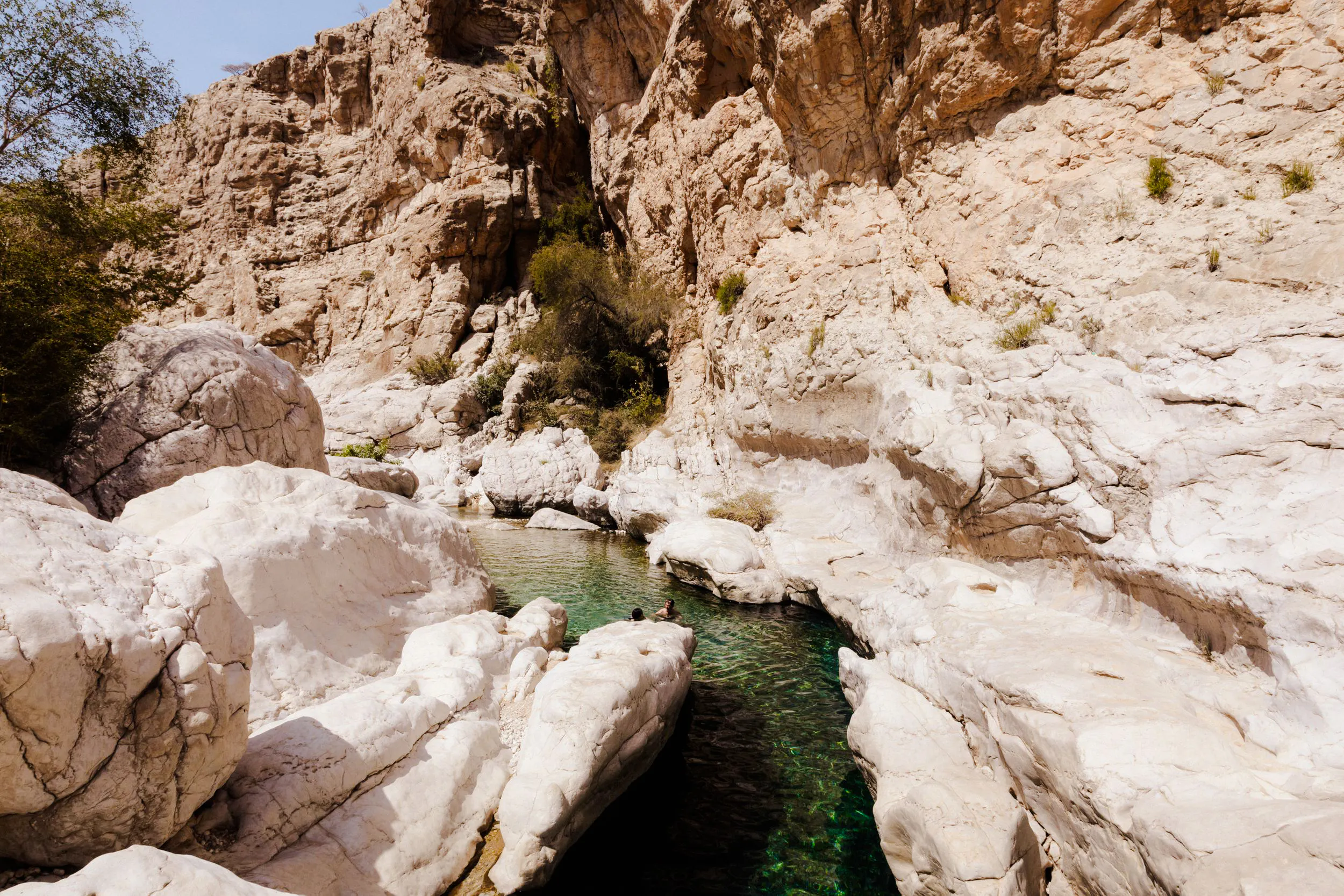 Wadi Bani Khalid's rocky landscape with clear water pools, part of Muscat's guided desert tour.