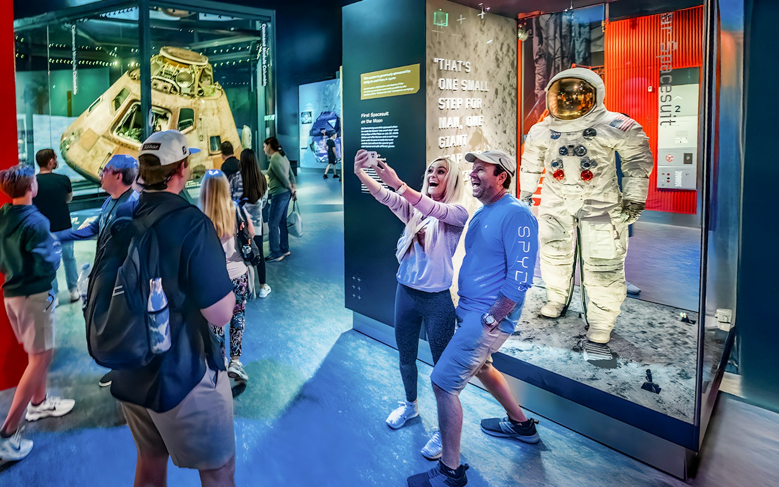 Visitors at Smithsonian's National Air and Space Museum in Washington DC, viewing Apollo capsule and spacesuit.