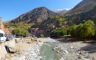 Mountain village with river and camels in Atlas Mountains near Marrakech.