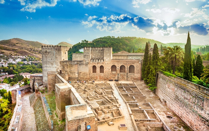 Alcazaba fortress at Alhambra, Granada, with scenic views of surrounding hills.