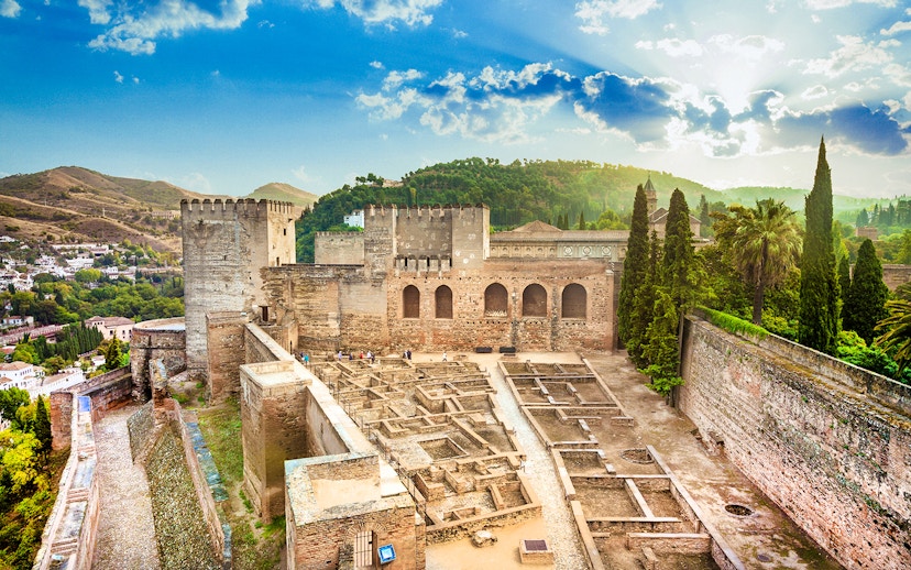 Alcazaba fortress at Alhambra, Granada, with scenic views of surrounding hills.