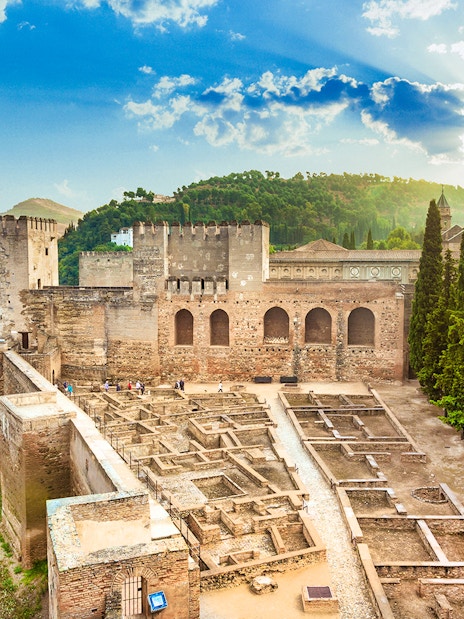 Alcazaba fortress at Alhambra, Granada, with scenic views of surrounding hills.