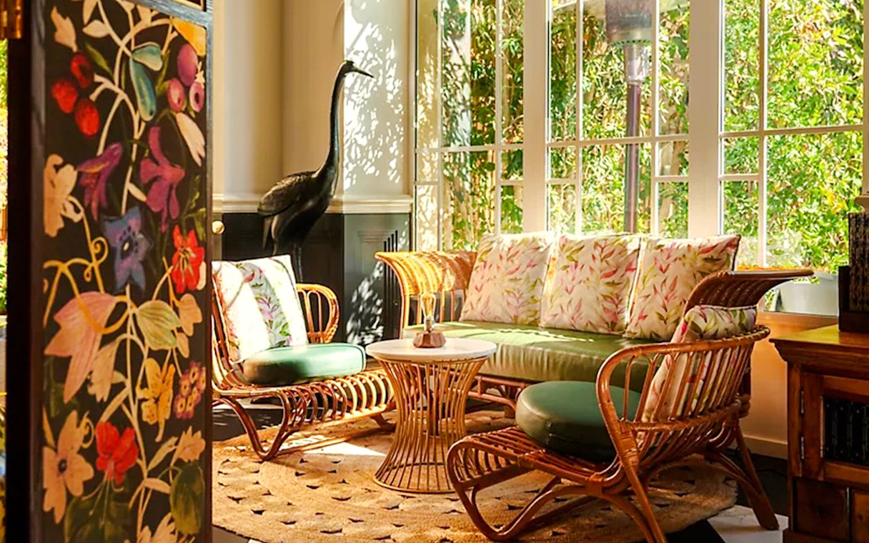 Rattan seating area with floral cushions in Fairmont Hotel sunlit room.