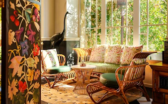 Rattan seating area with floral cushions in Fairmont Hotel sunlit room.