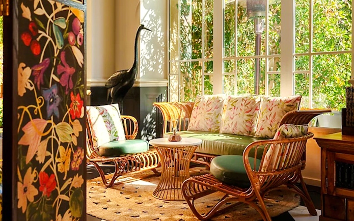 Rattan seating area with floral cushions in Fairmont Hotel sunlit room.
