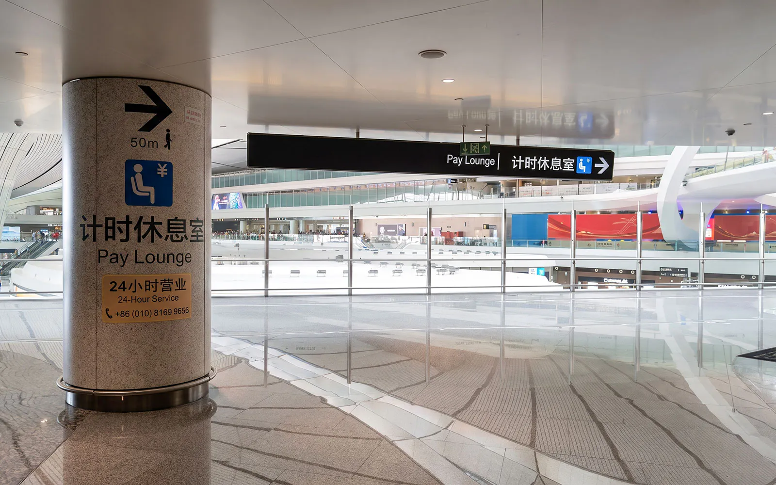 Pay lounge sign inside Beijing Daxing International Airport with directions and contact information.