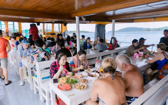 Tourists enjoying lunch on a boat during the 3 Island Hopping Tour in Phu Quoc.