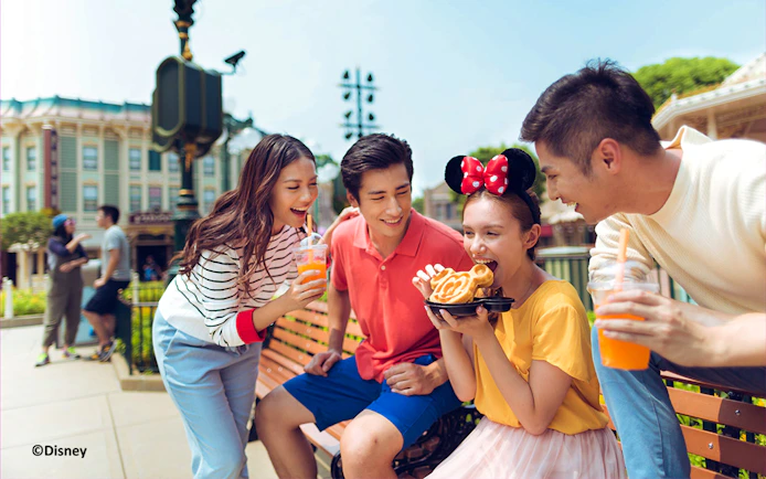 Visitors enjoying snacks with Hong Kong Disneyland meal voucher.
