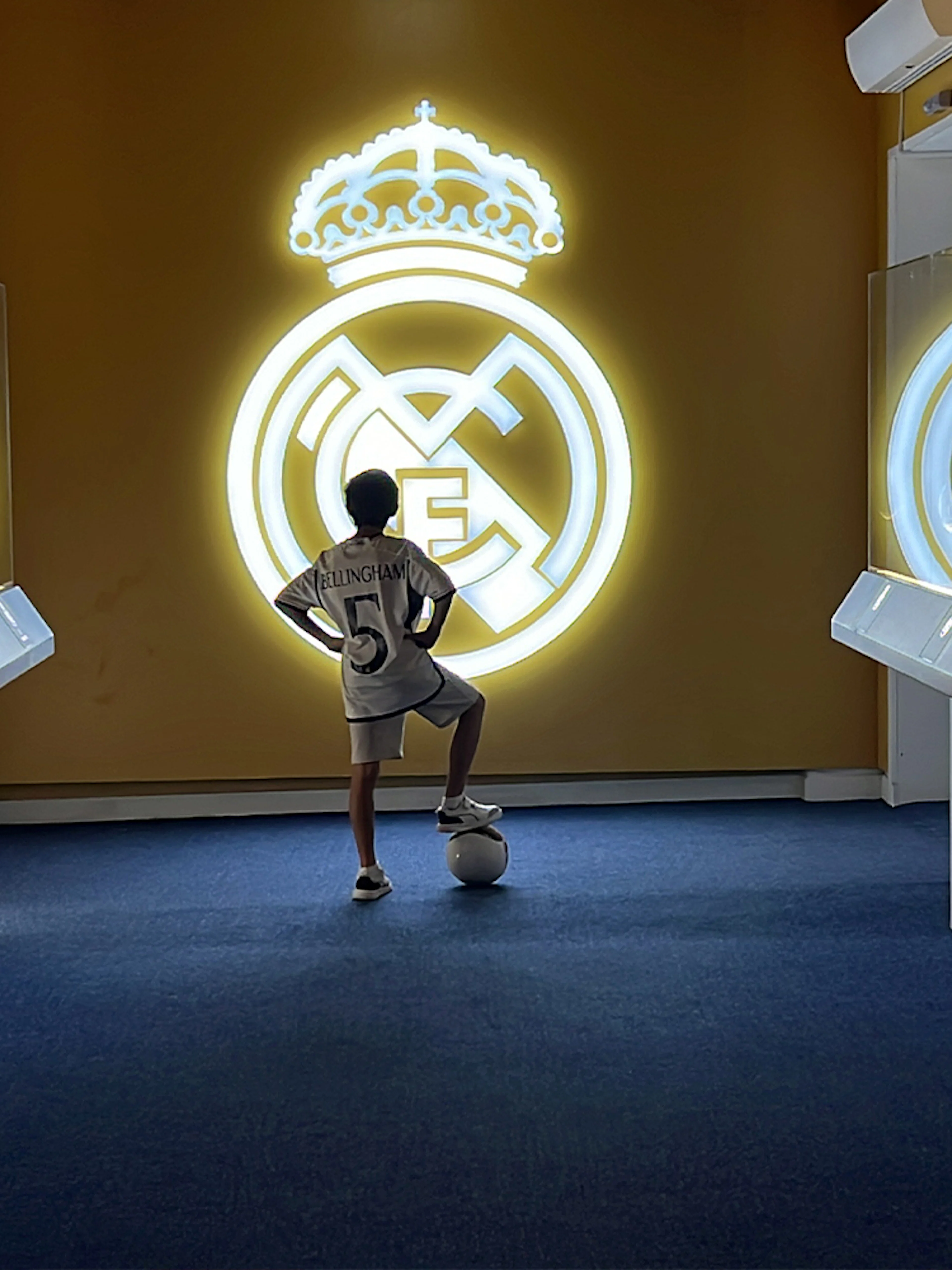 Child admiring Real Madrid logo at Real Madrid World, Dubai.